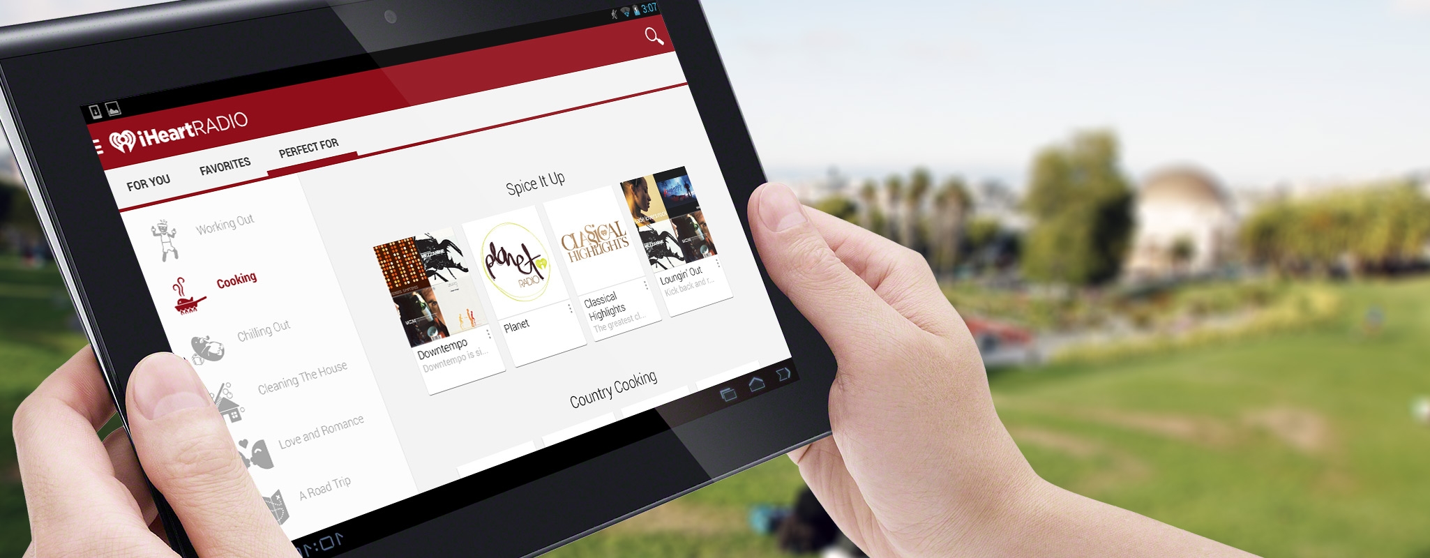 Hero image: Two hands holding a tablet showing iHeartRadio's tablet app